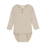 Der beige Body von MINYMO zeichnet sich durch seine feinen Holzknöpfe aus und überzeugt durch hochwertige Verarbeitung und angenehme Passform.