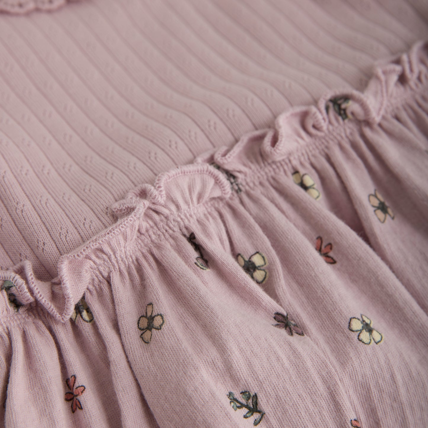 Verspieltes lila Kleid von MINYMO mit einem fröhlichen Blumenmuster am Rock.