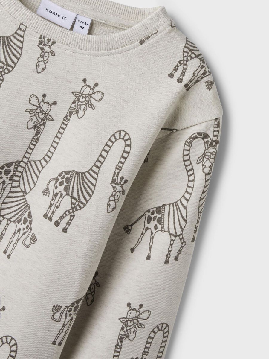 Dieses beige Sweatshirt von name it besticht durch einen durchgehenden Giraffen-Print, der dem Kleidungsstück einen einzigartigen Charakter verleiht.