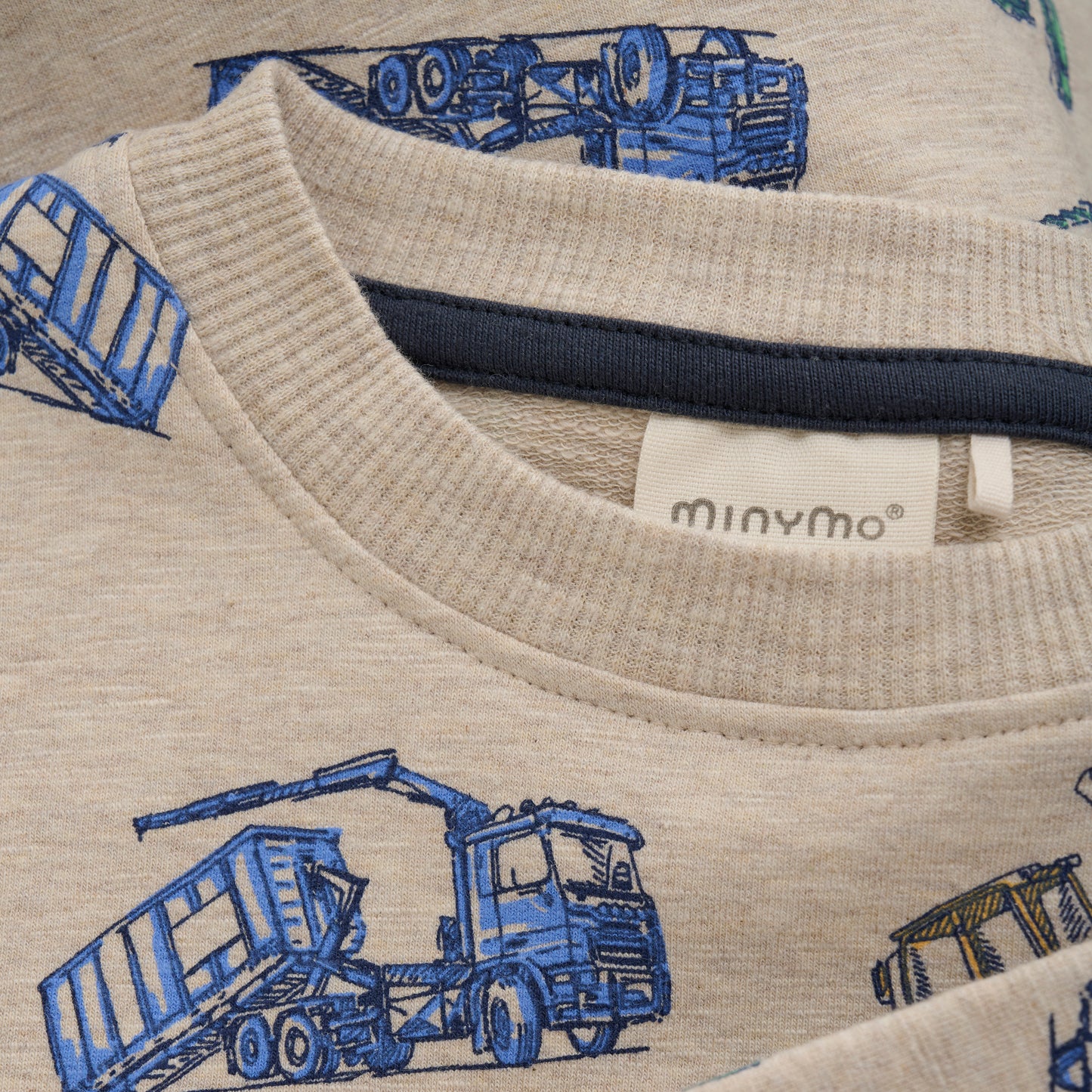 Das beige Sweatshirt von MINYMO zeigt fröhliche Baumaschinen und sorgt für einen verspielten Look mit viel Komfort.