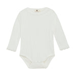 Dieser langärmelige Body von Enfant mit feiner Pointelle-Stickerei vereint zarten Komfort mit stilvoller Eleganz. Das atmungsaktive Material sorgt für ein angenehmes Tragegefühl, während das filigrane Muster jedem Outfit eine besondere Note verleiht. Perfekt für empfindliche Babyhaut und ideal für jeden Anlass, bei dem Komfort und Design Hand in Hand gehen.