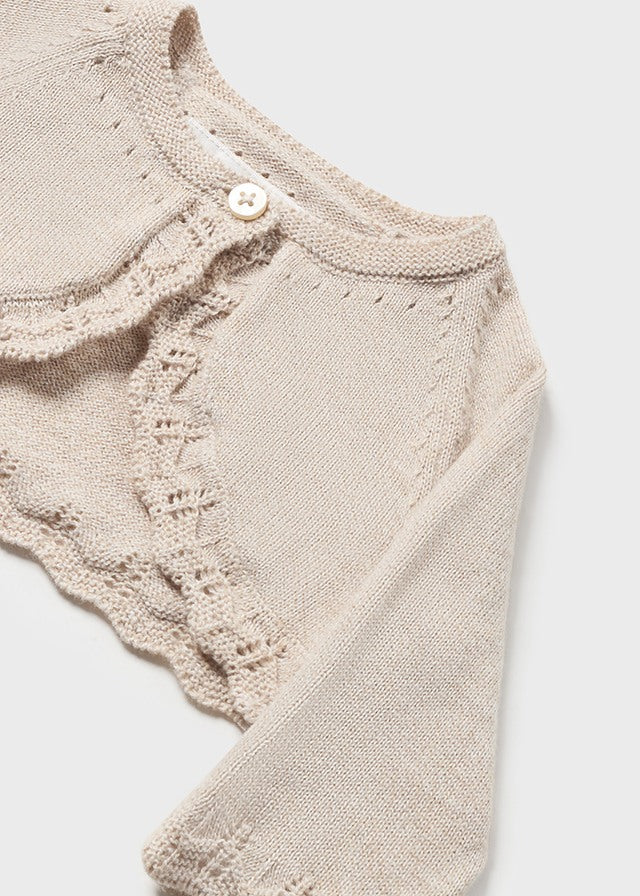 Langarm Strickjacke mit Rundkragen. Knopfverschluss am Kragen, um das Anziehen des Kleidungsstücks zu erleichtern. Strickgewebe, weich und angenehm auf der Haut.