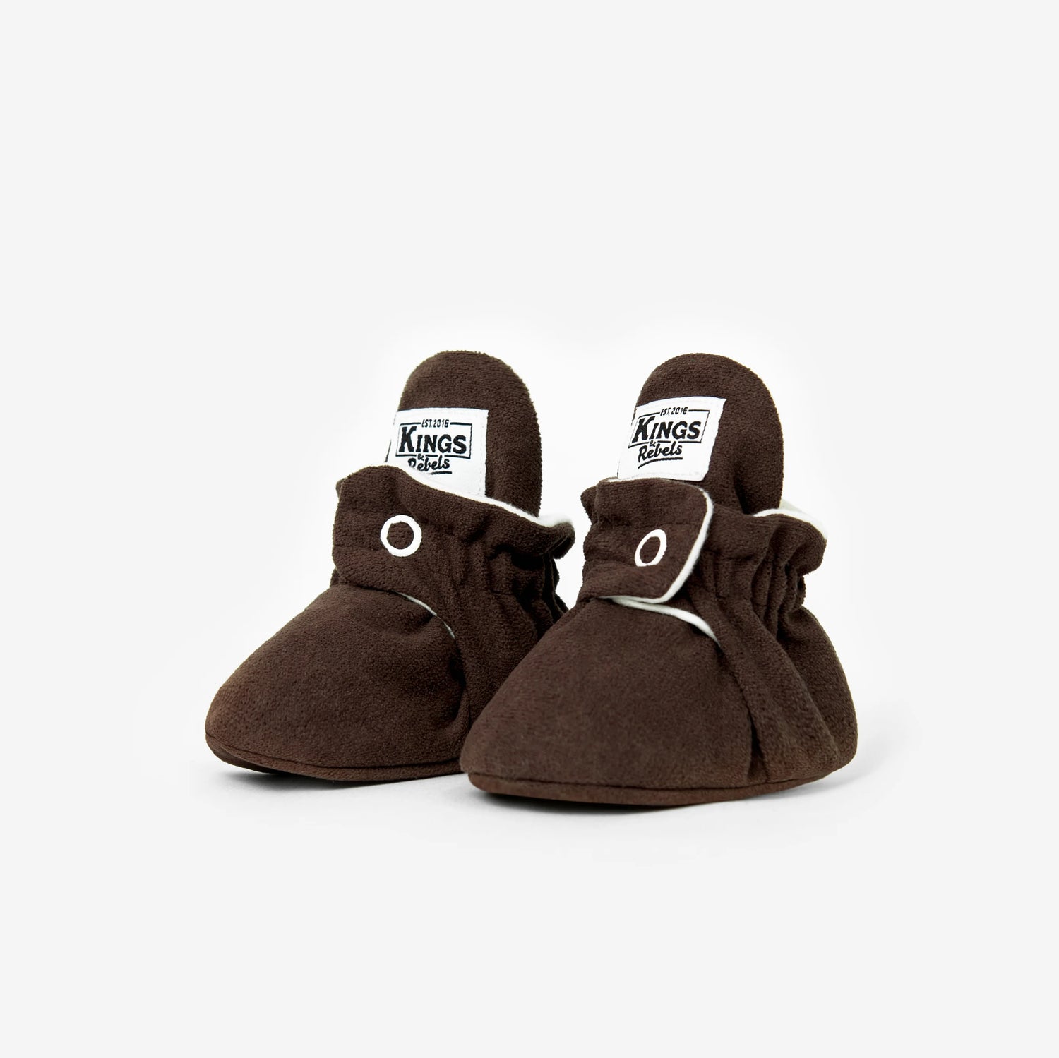 Die Kings & Rebels Baby Booties wurden mit einem einfachen und praktischen Druckknopf- Verschluss entworfen, was das Anziehen von strampelnden Babys in wenigen Sekunden ermöglicht.
Der komplett um die Ferse verlaufende und über dem Knöchel sitzende, integrierte Gummizug verhindert auch bei sehr aktiven Babys das Herunterrutschen des Booties.
Die Booties passen sich perfekt an die individuelle Form der Babyfüße an und schränken somit die natürliche Entwicklung in keinster Weise ein. 
Alle Kings &