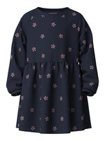 Das dunkelblaue Kleid mit Blumenmuster von name it besticht durch sein zeitloses Design und die hochwertige Verarbeitung. Der fließende Schnitt schmeichelt der Figur und eignet sich perfekt für verschiedene Anlässe – vom Alltag bis zum besonderen Event. Das atmungsaktive Material fühlt sich angenehm auf der Haut an und behält seine Form auch nach mehrmaligem Waschen. Das zarte Blumenmuster verleiht dem Kleid einen femininen Touch und macht es zu einem vielseitigen Lieblingsstück in jeder Garderobe.