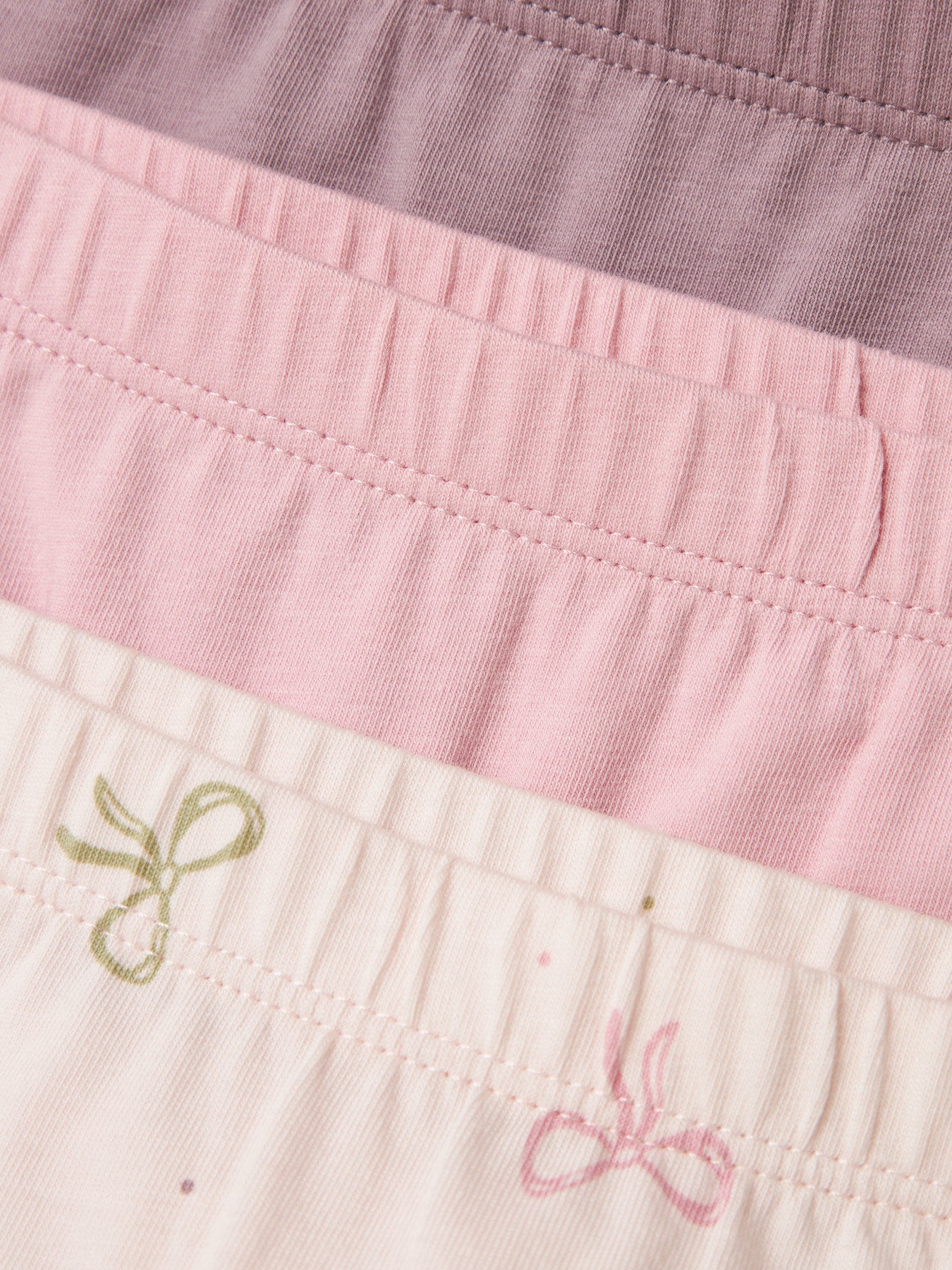 Die dreiteilige Panty-Kollektion von name it in den Farben Glimmer, Rosa und Schwarz überzeugt durch besonders weichen Tragekomfort.
