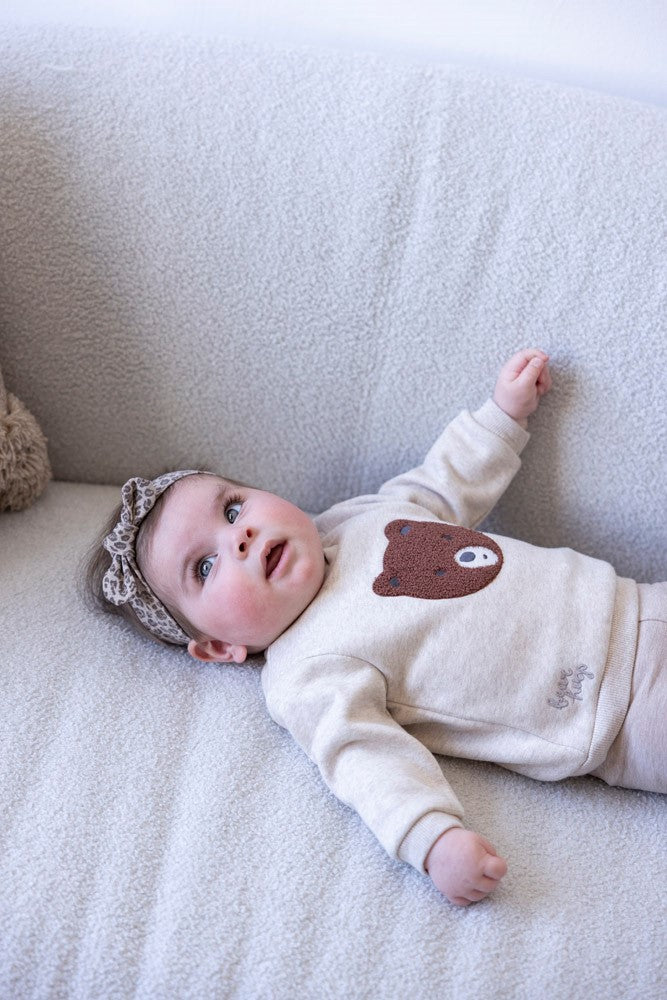 Dieser beiger Pullover aus der Wild World Kollektion von Feetje besticht durch ein edles, flauschiges braunes Bärenmotiv und verbindet Komfort mit stilvoller Eleganz.