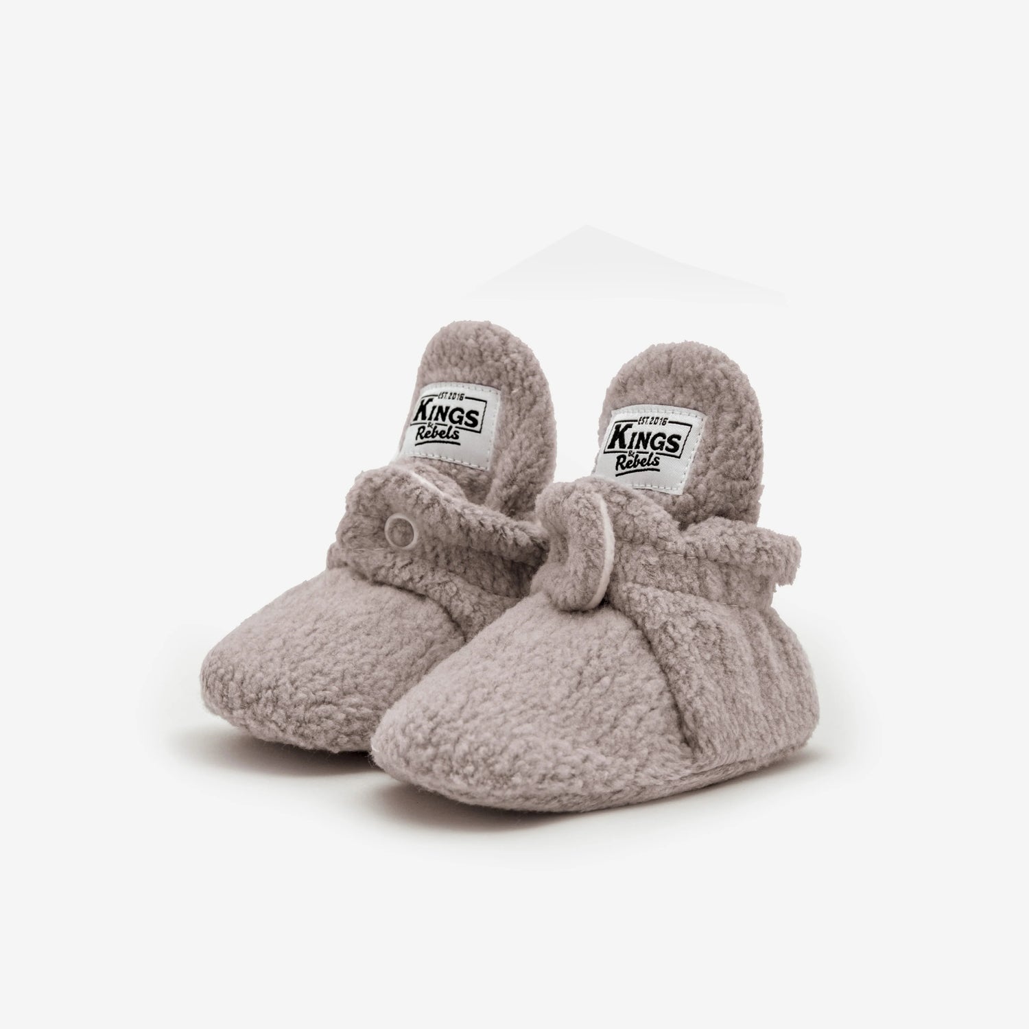 Die Kings & Rebels Baby Booties wurden mit einem einfachen und praktischen Druckknopf- Verschluss entworfen, was das Anziehen von strampelnden Babys in wenigen Sekunden ermöglicht.
Der komplett um die Ferse verlaufende und über dem Knöchel sitzende, integrierte Gummizug verhindert auch bei sehr aktiven Babys das Herunterrutschen des Booties.
Die Booties passen sich perfekt an die individuelle Form der Babyfüße an und schränken somit die natürliche Entwicklung in keinster Weise ein. 
Alle Kings &
