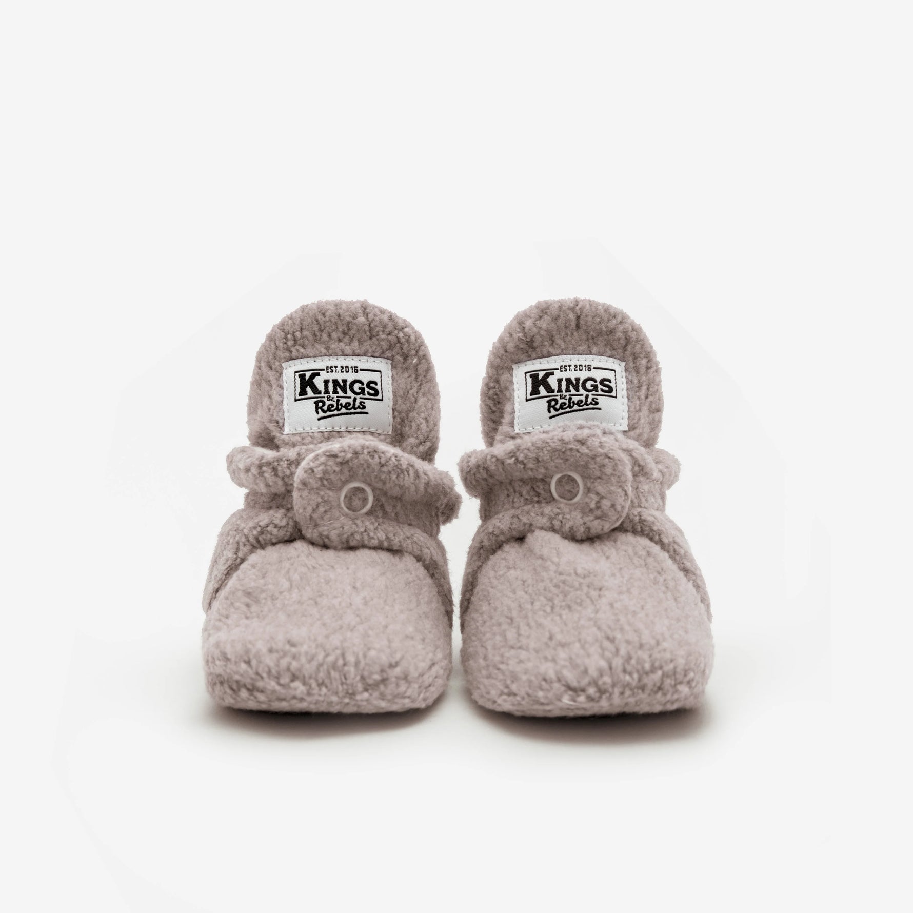 Die Kings & Rebels Baby Booties wurden mit einem einfachen und praktischen Druckknopf- Verschluss entworfen, was das Anziehen von strampelnden Babys in wenigen Sekunden ermöglicht.
Der komplett um die Ferse verlaufende und über dem Knöchel sitzende, integrierte Gummizug verhindert auch bei sehr aktiven Babys das Herunterrutschen des Booties.
Die Booties passen sich perfekt an die individuelle Form der Babyfüße an und schränken somit die natürliche Entwicklung in keinster Weise ein. 
Alle Kings &