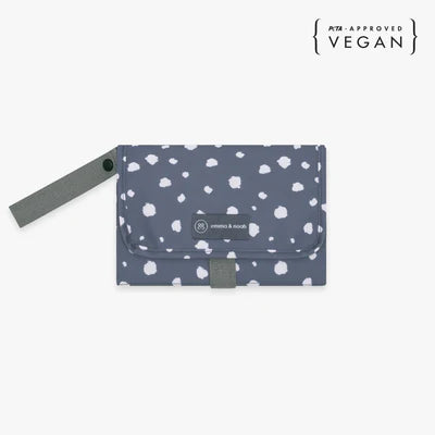 Die Wickelunterlage mit blauen Punkten ist ideal für unterwegs. Sie lässt sich einfach am Handgelenk oder Kinderwagen befestigen und bietet dank Innentaschen Platz für Windeln und Pflegeartikel. Nach Gebrauch wird sie kompakt zusammengefaltet, sodass Du jederzeit schnell und hygienisch wickeln kannst.