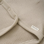 Der beige Body von MINYMO zeichnet sich durch seine feinen Holzknöpfe aus und überzeugt durch hochwertige Verarbeitung und angenehme Passform.