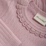 Dieses lilafarbene Body von MINYMO begeistert mit verspielten Rüschen am Kragen und zarten kleinen Details, die für einen charmanten Look sorgen.