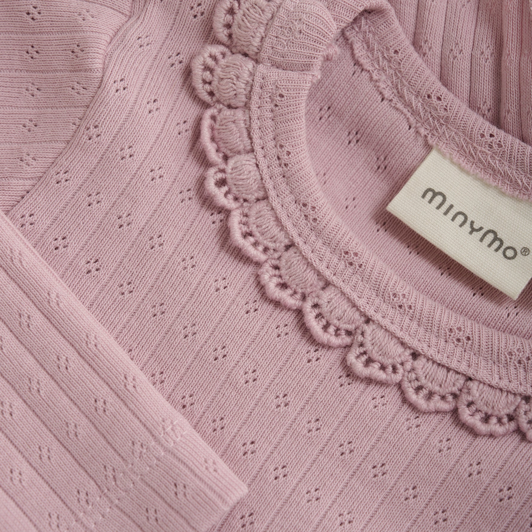 Dieses lilafarbene Body von MINYMO begeistert mit verspielten Rüschen am Kragen und zarten kleinen Details, die für einen charmanten Look sorgen.