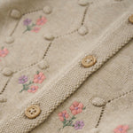 Der beige Cardigan von MINYMO besticht durch seine sorgfältig gearbeiteten Blumenverzierungen und verbindet zeitloses Design mit liebevollen Details.