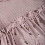 Verspieltes lila Kleid von MINYMO mit einem fröhlichen Blumenmuster am Rock.