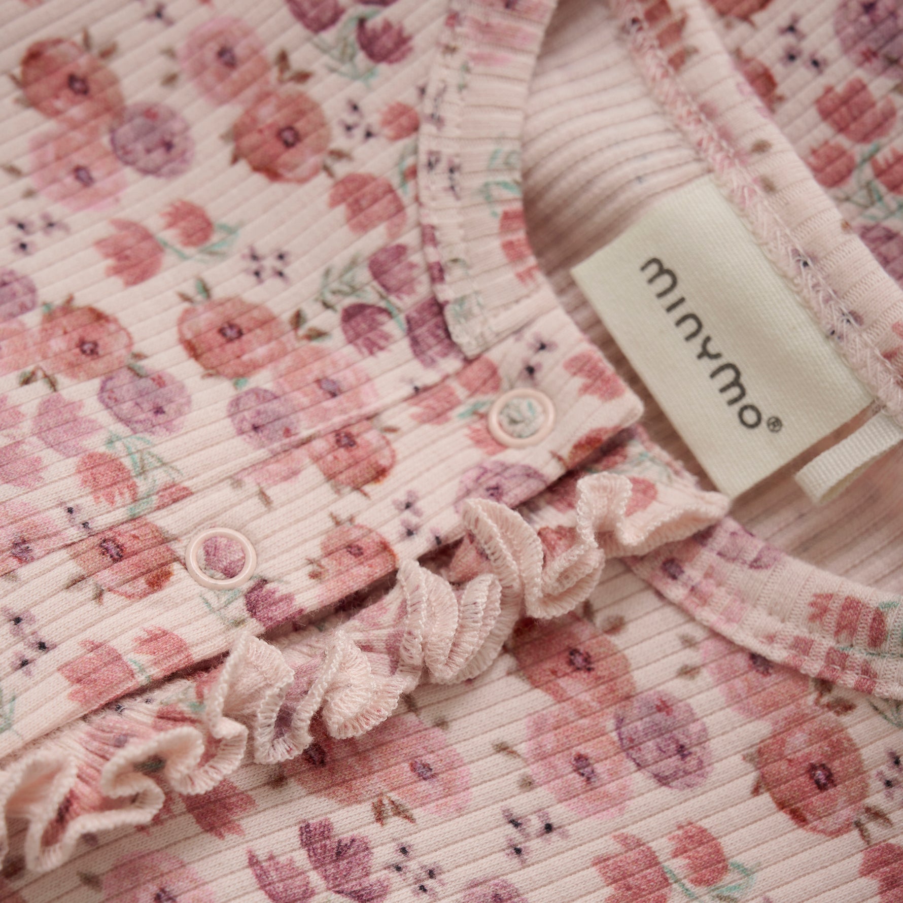 Eleganter rosa Body von MINYMO, verziert mit einem feinen Blumendesign, das zeitlose Schönheit ausstrahlt.