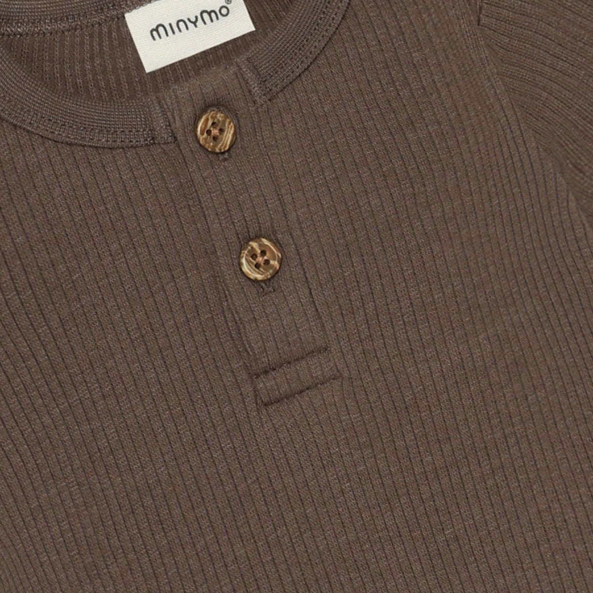 Ein zeitloser brauner Langarm-Rib-Body von Minymo, perfekt für vielseitige Styling-Möglichkeiten. Die hochwertige Materialmischung aus Modal, Baumwolle und Elastane bietet optimalen Komfort und Bewegungsfreiheit. Ideal als Basis-Piece für jeden Kleiderschrank.