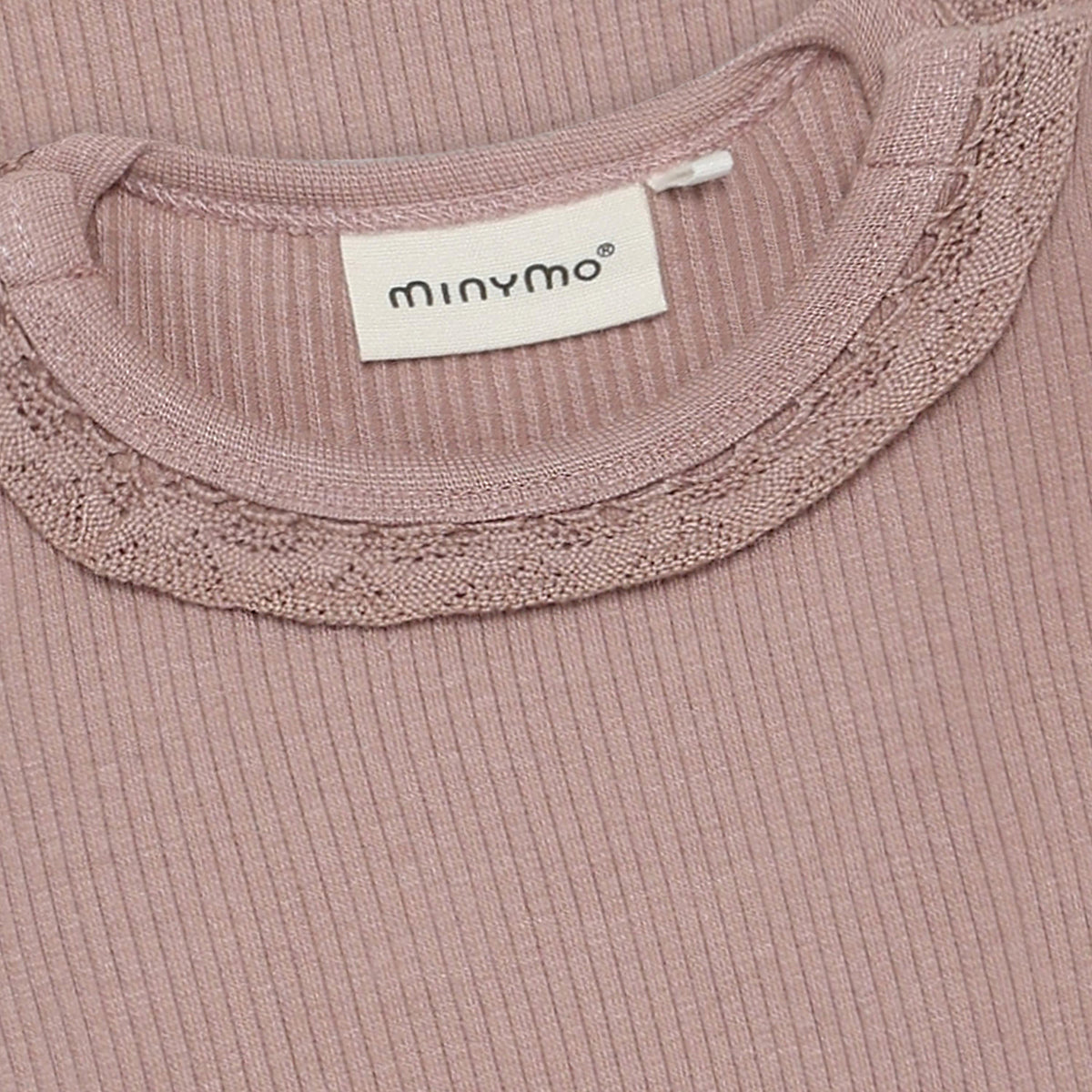 Ein eleganter Langarm-Rib-Body in zartem Altrosa von Minymo. Die hochwertige Materialmischung aus Modal, Baumwolle und Elastane bietet optimalen Tragekomfort und sanfte Elastizität. Perfekt für vielseitige Styling-Möglichkeiten im Alltag.