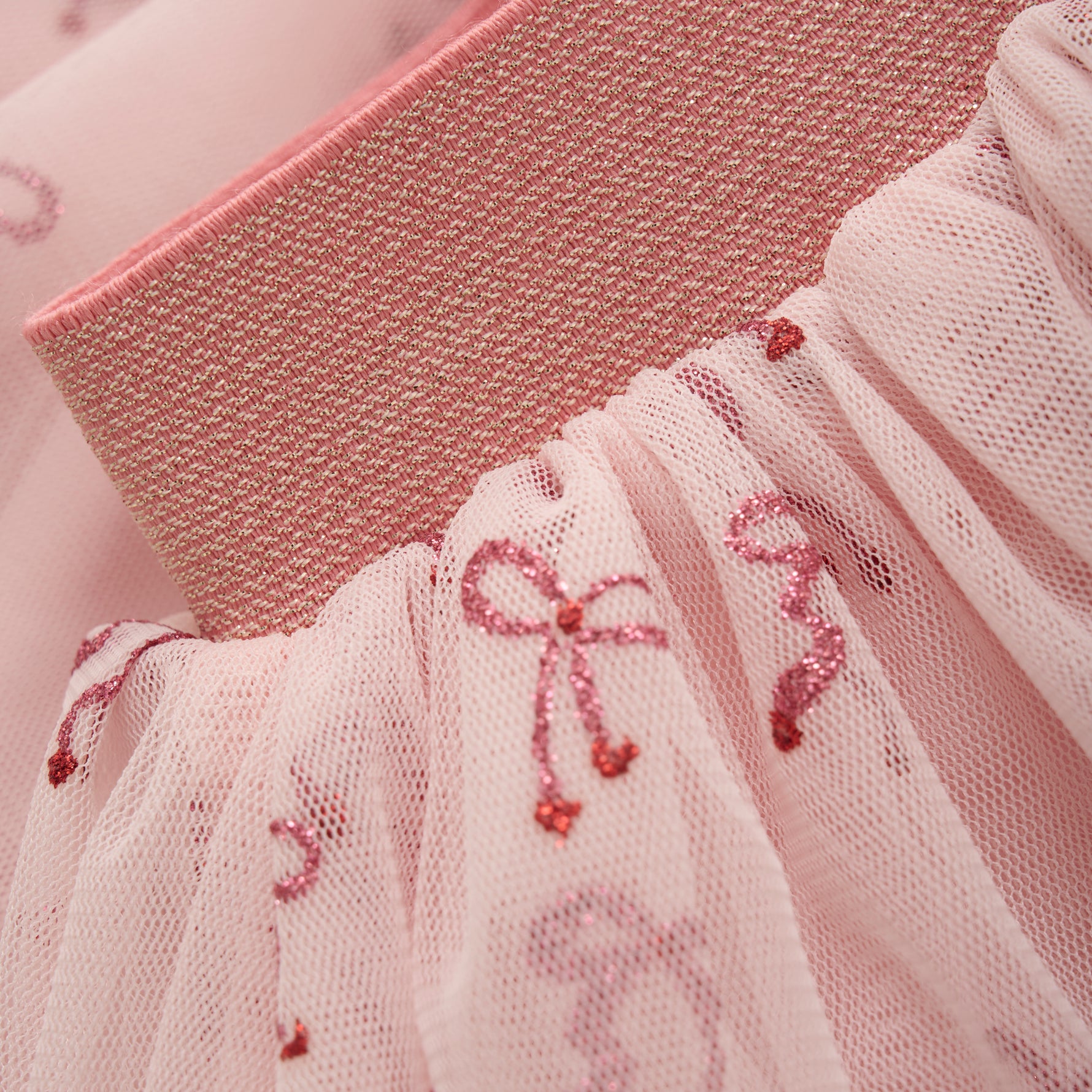 Der rosa Rock von MINYMO begeistert mit funkelnden Schleifen und verleiht jedem Look eine besondere Note.