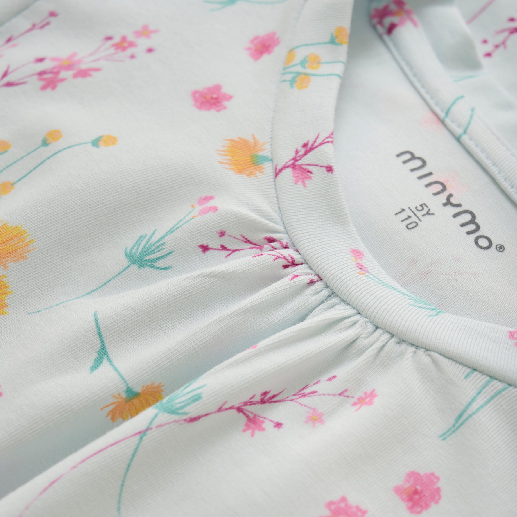 Dieses weiße Kleid mit floralem Allover-Print stammt von MINYMO und besticht durch sein elegantes Design.