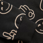 Dieses schwarze Sweatshirt mit Kapuze von MINYMO ist mit fröhlichen Smileys bedruckt und sorgt für gute Laune.