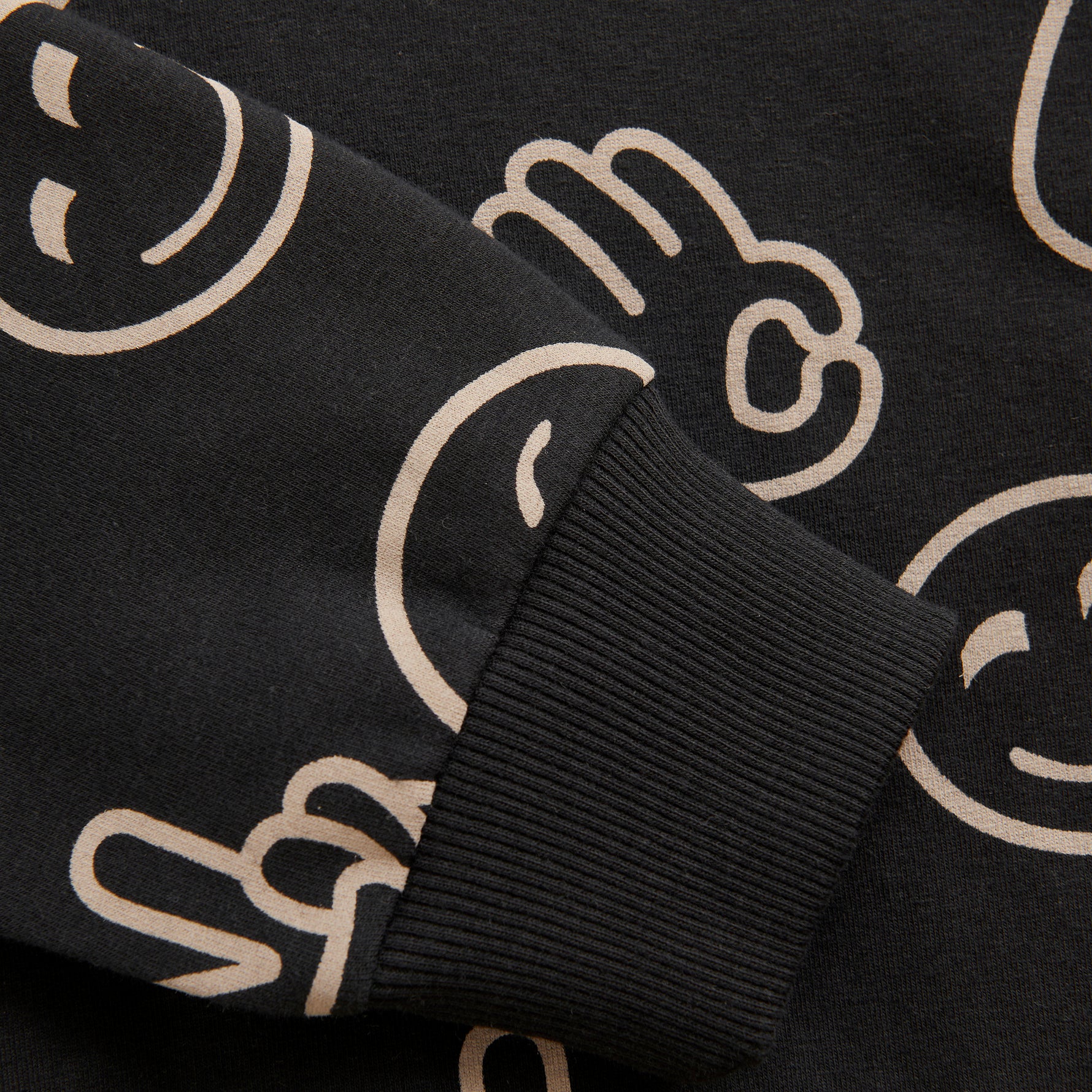 Dieses schwarze Sweatshirt mit Kapuze von MINYMO ist mit fröhlichen Smileys bedruckt und sorgt für gute Laune.