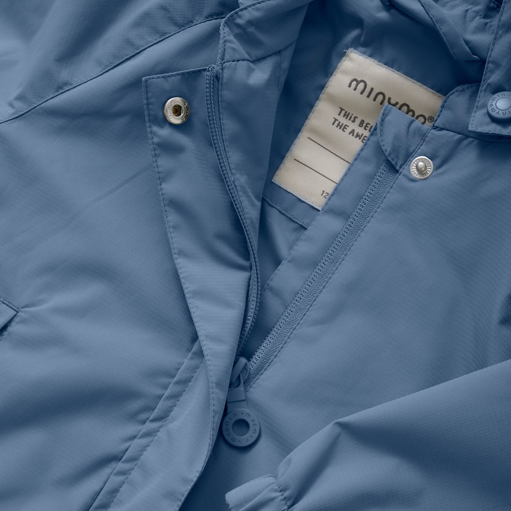 Diese blaue Regenjacke von MINYMO bietet zuverlässigen Schutz bei nassem Wetter und überzeugt durch hochwertige Verarbeitung und funktionales Design.