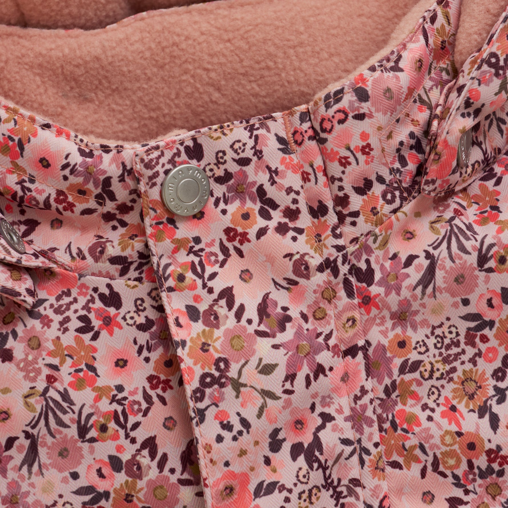 Diese rosa Schneejacke von MINYMO besticht durch ihren durchgehenden Blumenprint und bietet zuverlässigen Schutz bei kaltem Wetter.
