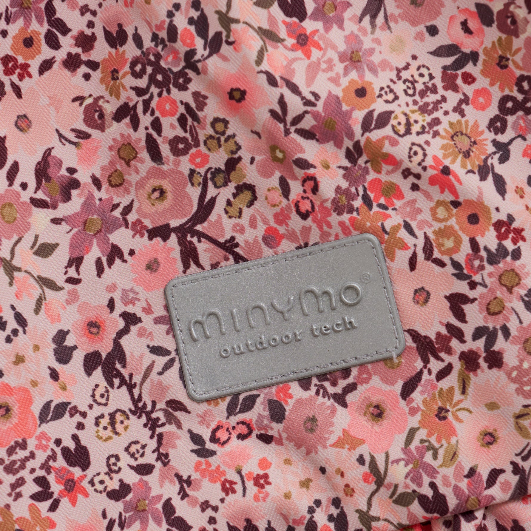 Diese rosa Schneejacke von MINYMO besticht durch ihren durchgehenden Blumenprint und bietet zuverlässigen Schutz bei kaltem Wetter.