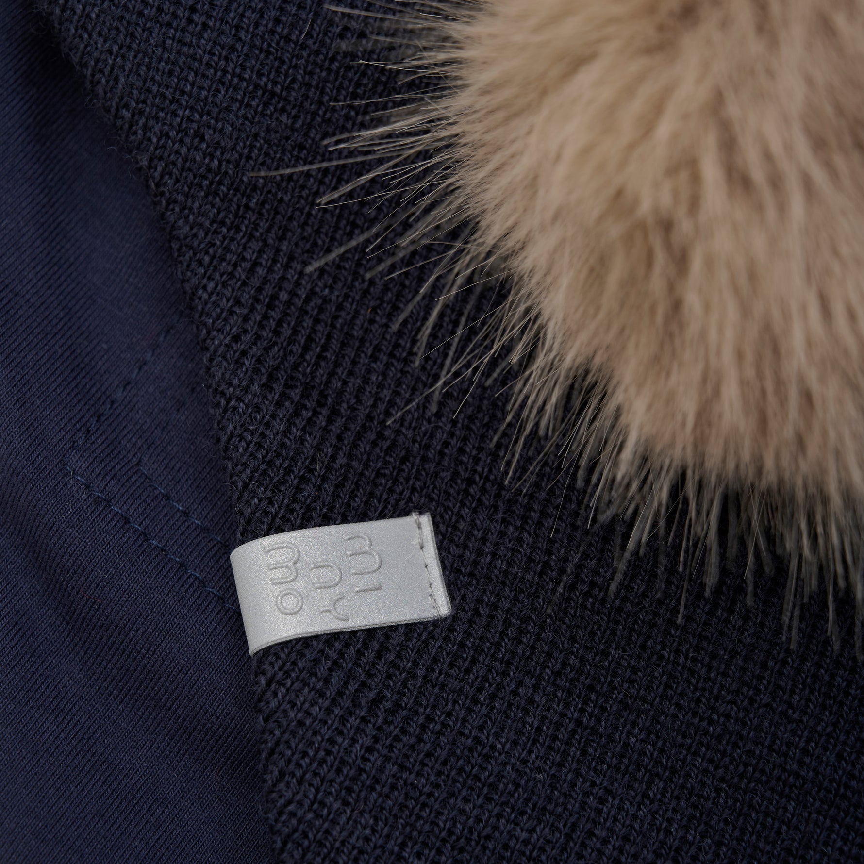 Diese dunkelblaue Mütze von MINYMO begeistert mit einem abnehmbaren Fellbommel – perfekt, um deinen Look je nach Stimmung zu verändern!