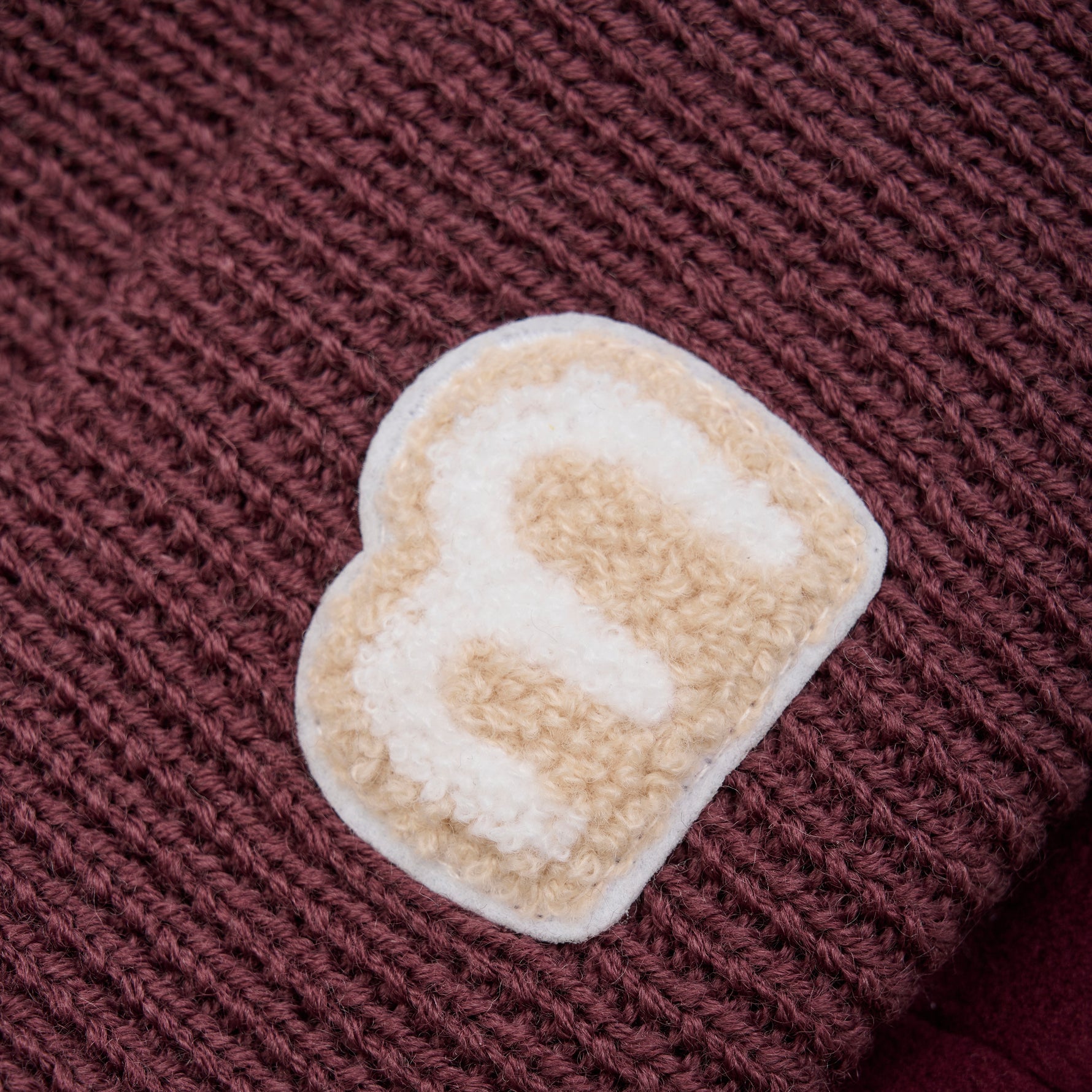 Diese dunkelrote Mütze von MINYMO bietet stilvollen Schutz und Komfort für kühle Tage.