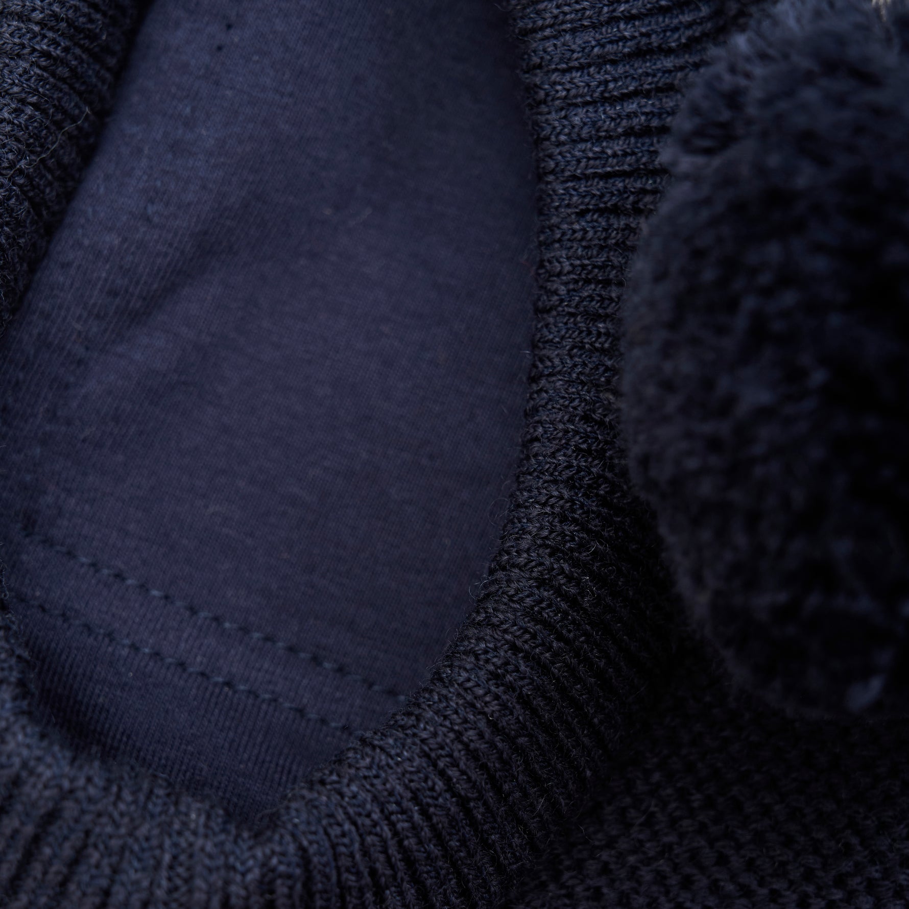 Diese dunkelblaue Haube von MINYMO ist mit einem kleinen Pompom verziert und bietet angenehmen Schutz bei kühlem Wetter.