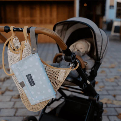 Die Wickelunterlage Punkte Mint ist ideal für unterwegs. Sie lässt sich einfach am Handgelenk oder Kinderwagen befestigen und bietet dank Innentaschen Platz für Windeln und Pflegeartikel. Nach dem Wickeln wird sie kompakt zusammengefaltet – so bist du jederzeit gut vorbereitet.