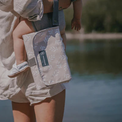 Die Wickelunterlage in Sand ist kompakt und praktisch für unterwegs. Sie bietet Stauraum für Windeln und Pflegeartikel in Innentaschen, sodass alles griffbereit ist. Einfach am Handgelenk oder Kinderwagen zu befestigen und nach Gebrauch platzsparend zusammenfaltbar. Ideal, um jederzeit schnell und hygienisch zu wickeln.