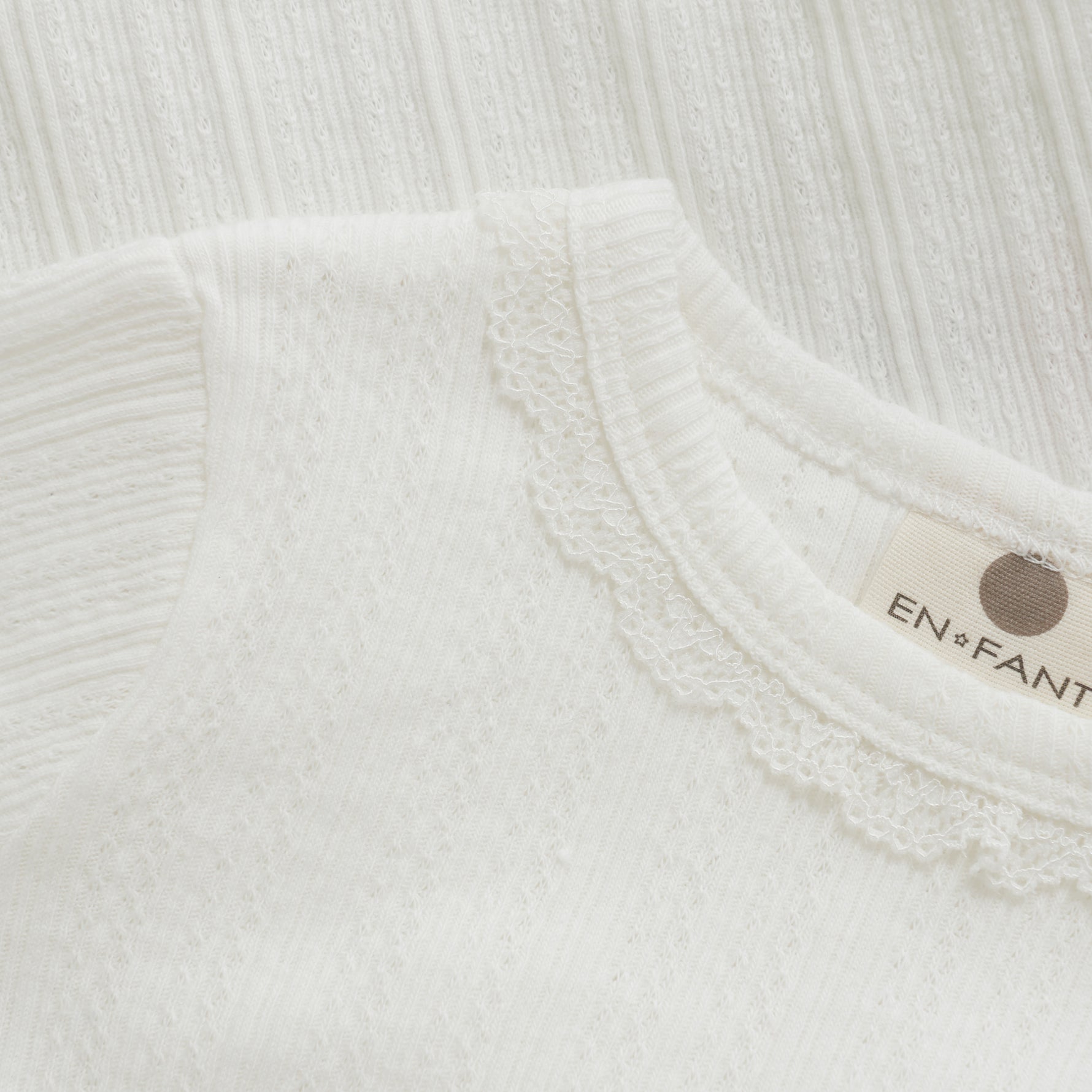 Dieser langärmelige Body von Enfant mit feiner Pointelle-Stickerei vereint zarten Komfort mit stilvoller Eleganz. Das atmungsaktive Material sorgt für ein angenehmes Tragegefühl, während das filigrane Muster jedem Outfit eine besondere Note verleiht. Perfekt für empfindliche Babyhaut und ideal für jeden Anlass, bei dem Komfort und Design Hand in Hand gehen.
