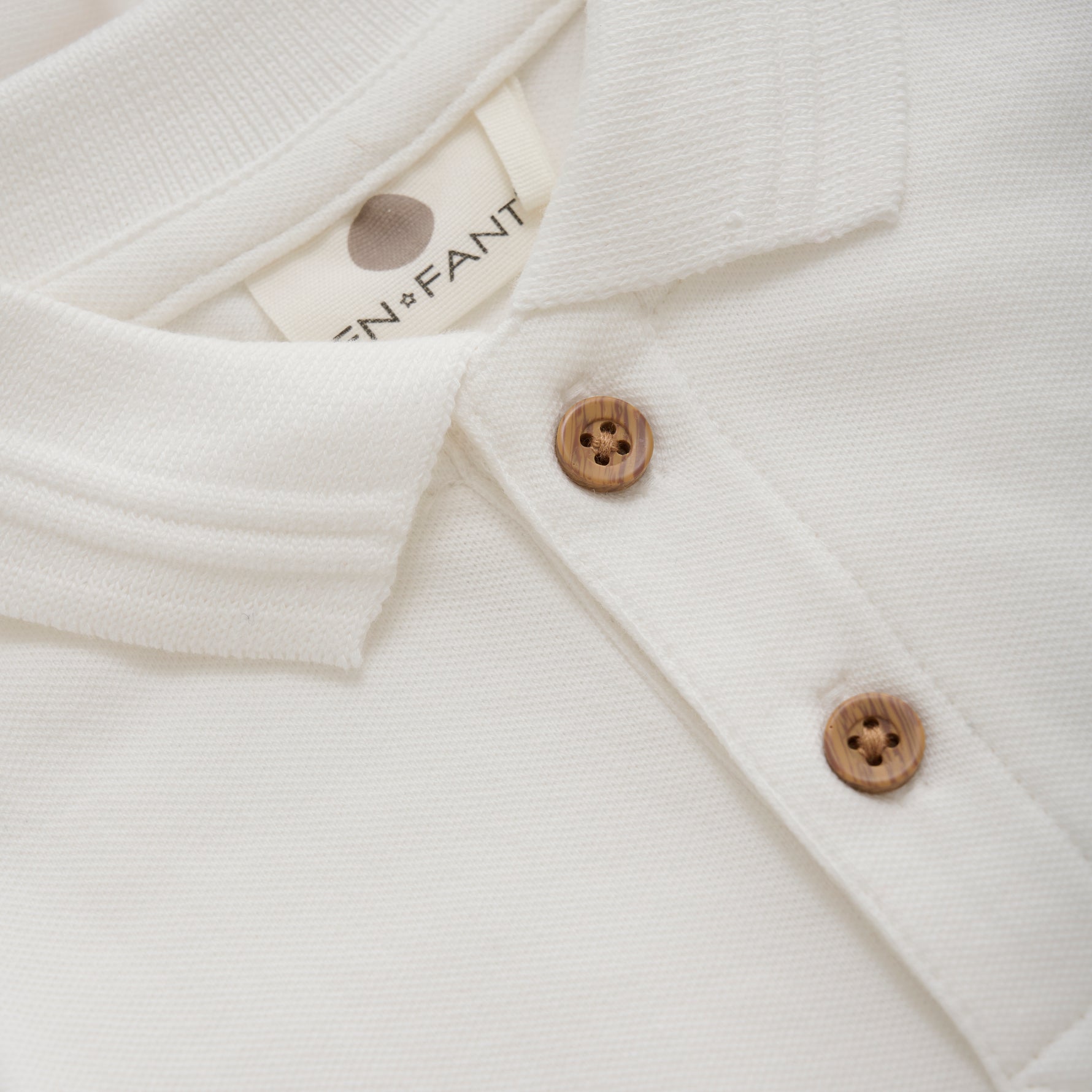 Dieser weiße Langarm-Body im Polo-Stil von Enfant vereint Komfort und Stil perfekt für Ihr Baby.