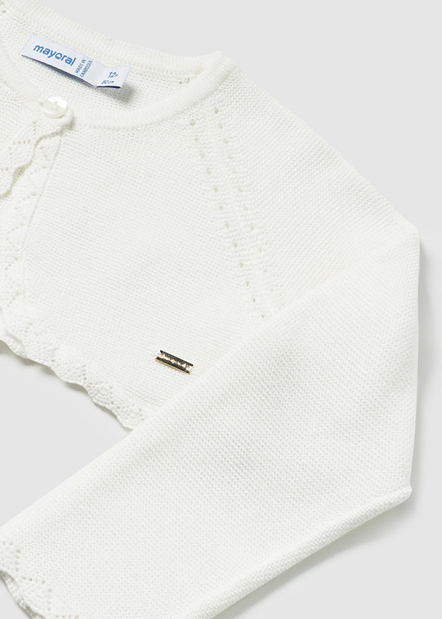 Langarm Strickjacke mit Rundkragen. Knopfverschluss am Kragen, um das Anziehen des Kleidungsstücks zu erleichtern. Strickgewebe, weich und angenehm auf der Haut.