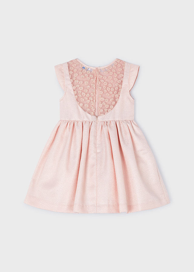 Kurzarm Kleid für Mädchen. Verdeckter Reißverschluss am Rücken. Zusammensetzung aus verschiedenen Stoffen, für ein einzigartiges Design. Design mit Tüllstickerei im Rückenbereich. Zierelemente: Blumen-Applikationen.