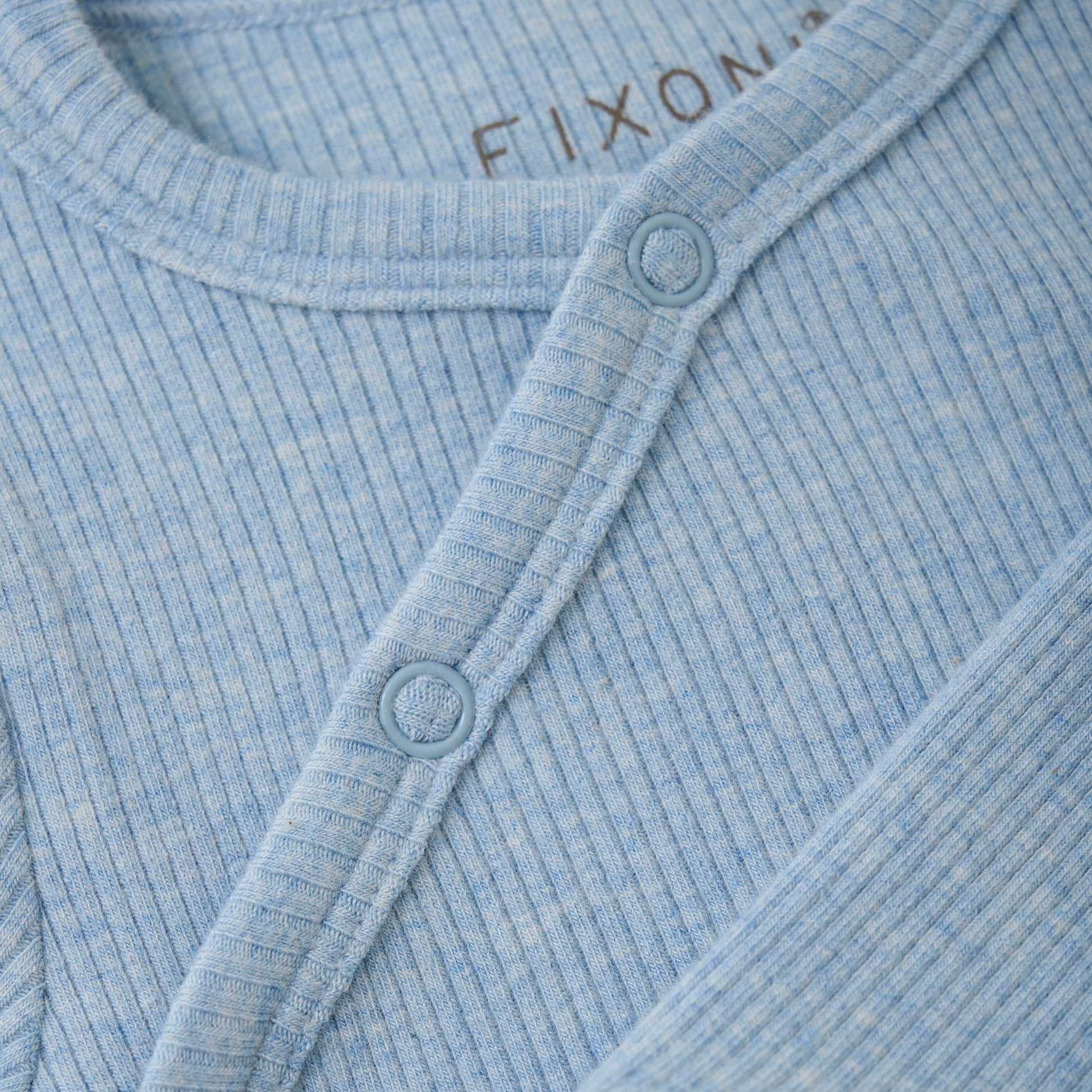 Der gerippte Wickel-Body in Blau von Fixoni besticht durch eine Mischung aus Modal und&nbsp; Baumwolle und bietet somit angenehmen Tragekomfort für Ihr Baby. Das praktische Design sorgt für einfache Handhabung und hält Ihr Kind warm und geschützt. Ideal für den Alltag und vielseitig kombinierbar.