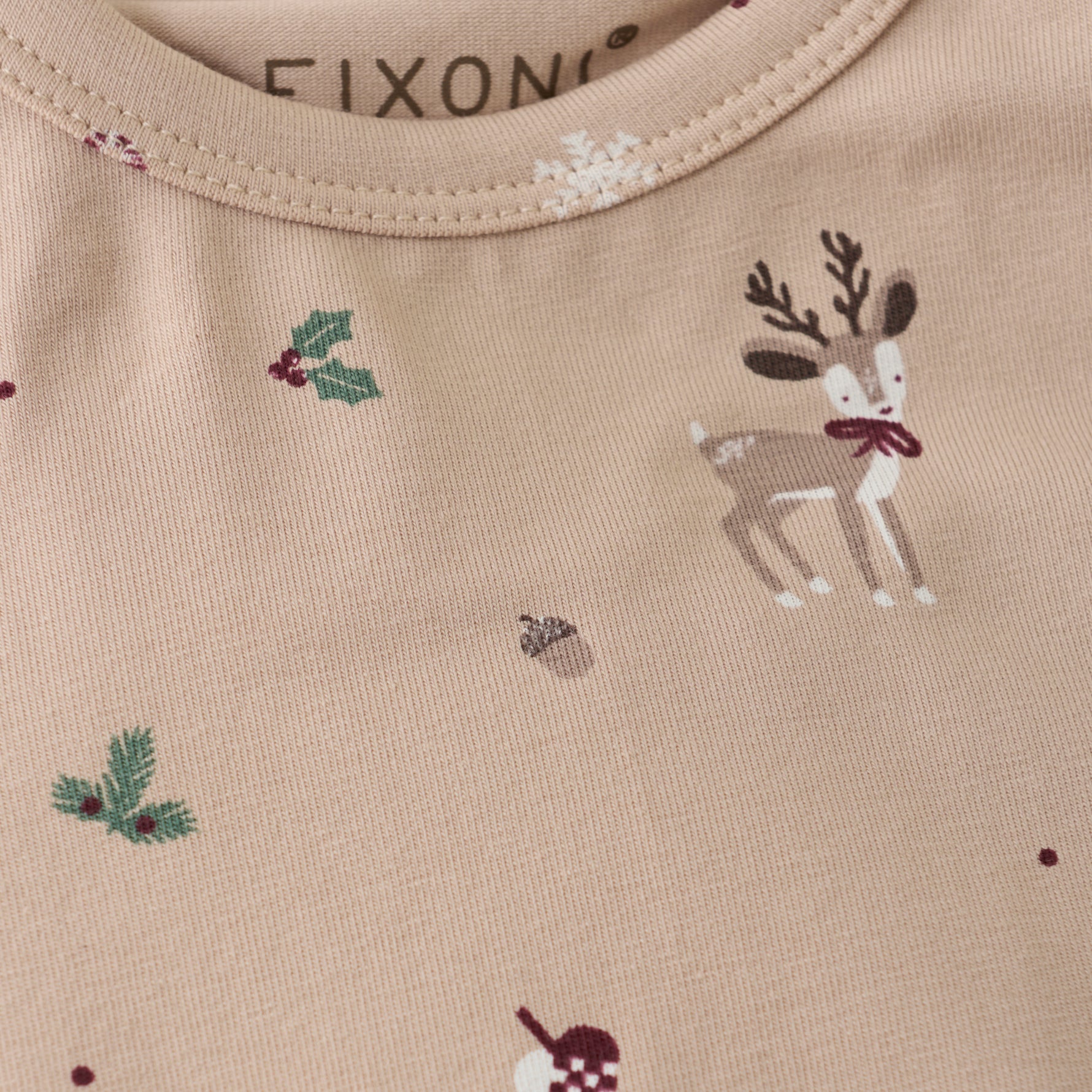 Dieser beige Langarm-Body von Fixoni überzeugt mit dezenten Weihnachtsmotiven und sorgt für festliche Stimmung bei Ihrem Baby.