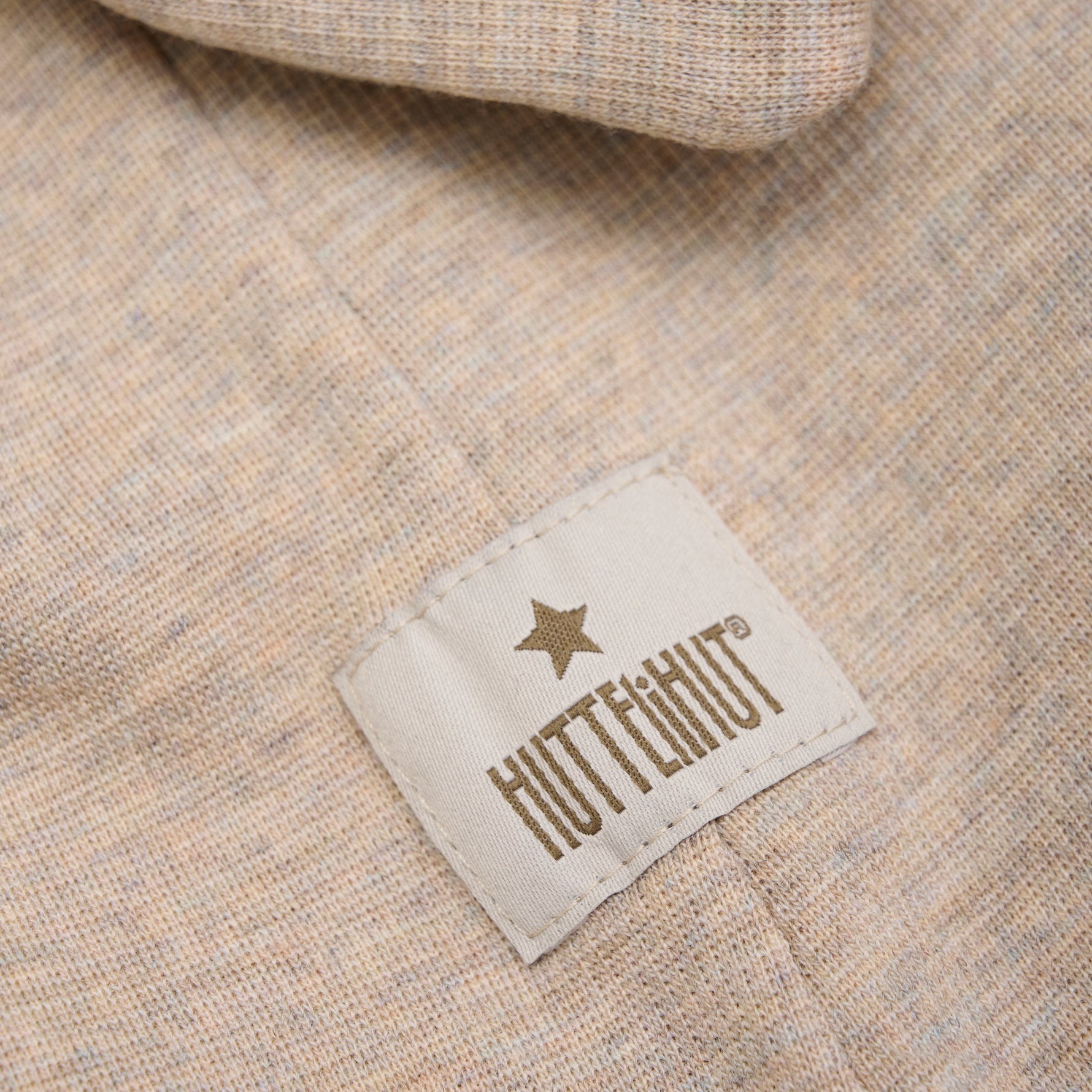 Diese beige, gerippte Wollhaube von Huttelihut bietet angenehme Wärme und stilvollen Schutz bei kaltem Wetter.