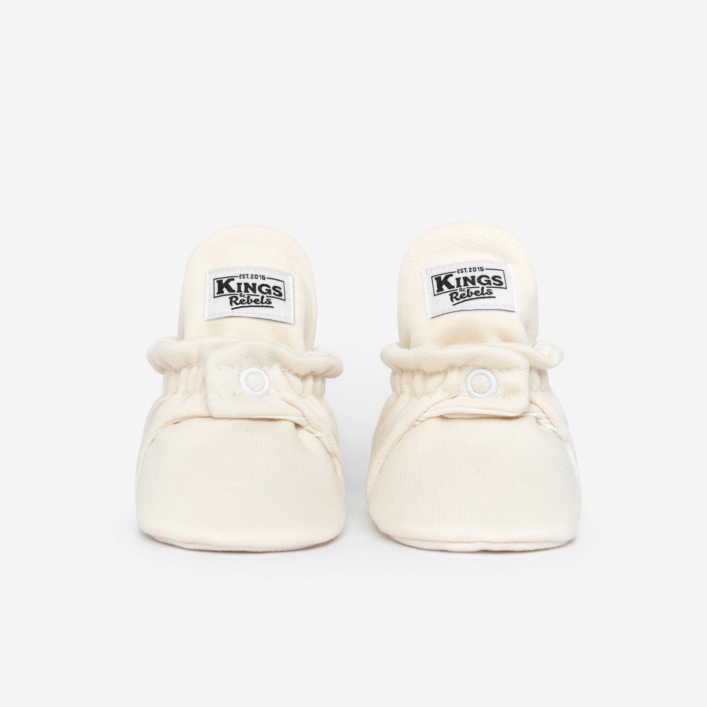 Die Kings &amp; Rebels Baby Booties wurden mit einem einfachen und praktischen Druckknopf- Verschluss entworfen, was das Anziehen von strampelnden Babys in wenigen Sekunden ermöglicht.

Der komplett um die Ferse verlaufende und über dem Knöchel sitzende, integrierte Gummizug verhindert auch bei sehr aktiven Babys das Herunterrutschen des Booties.

Alle Modelle der ´Cotton Classic´ und ´Cotton Gripper´ Linie sind aus haut- und umweltfreundlicher Baumwolle gefertigt, was für hohen Tragekomfort auch bei frühli