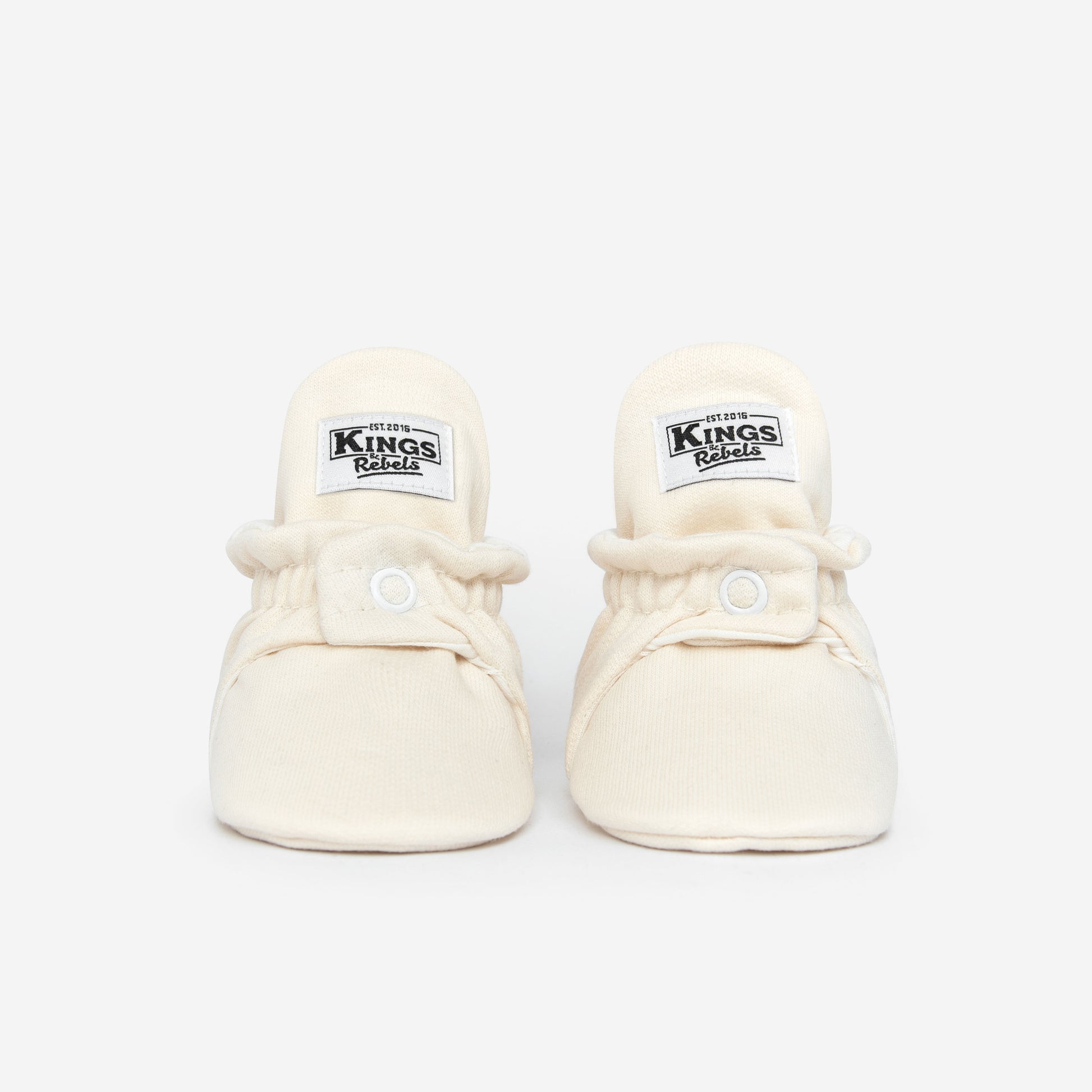 Die Kings &amp; Rebels Baby Booties wurden mit einem einfachen und praktischen Druckknopf- Verschluss entworfen, was das Anziehen von strampelnden Babys in wenigen Sekunden ermöglicht.

Der komplett um die Ferse verlaufende und über dem Knöchel sitzende, integrierte Gummizug verhindert auch bei sehr aktiven Babys das Herunterrutschen des Booties.

Alle Modelle der ´Cotton Classic´ und ´Cotton Gripper´ Linie sind aus haut- und umweltfreundlicher Baumwolle gefertigt, was für hohen Tragekomfort auch bei frühli