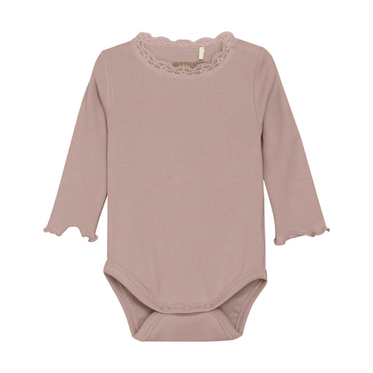 Dieser langarm Body von Huttelihut ist perfekt für Babys, die stilvoll und bequem gekleidet sein wollen. Mit süßer Spitze am Hals und Rüschen den Ärmeln ist er nicht nur ein Hingucker, sondern auch angenehm zu tragen. Hergestellt aus weichem Material, bietet er optimale Bewegungsfreiheit und hält das Baby warm.