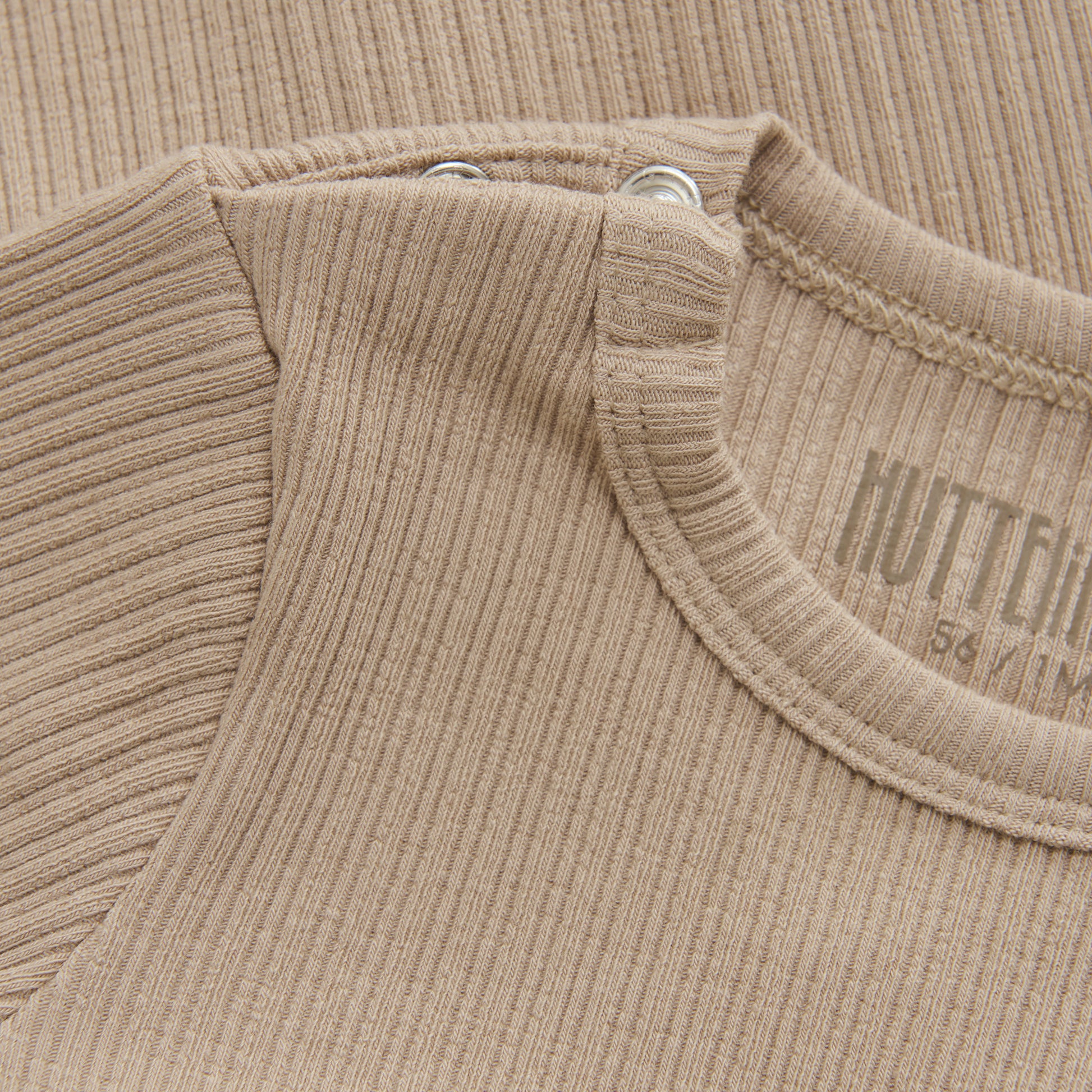 Entdecken Sie unseren kuscheligen und bequemen Basic Body langarm in beige für Babys. Die weichen Rippungen bieten höchsten Tragekomfort und schmiegen sich sanft an die empfindliche Haut Ihres Babys an. Perfekt für den Alltag, damit Ihr Kind sich frei bewegen kann.