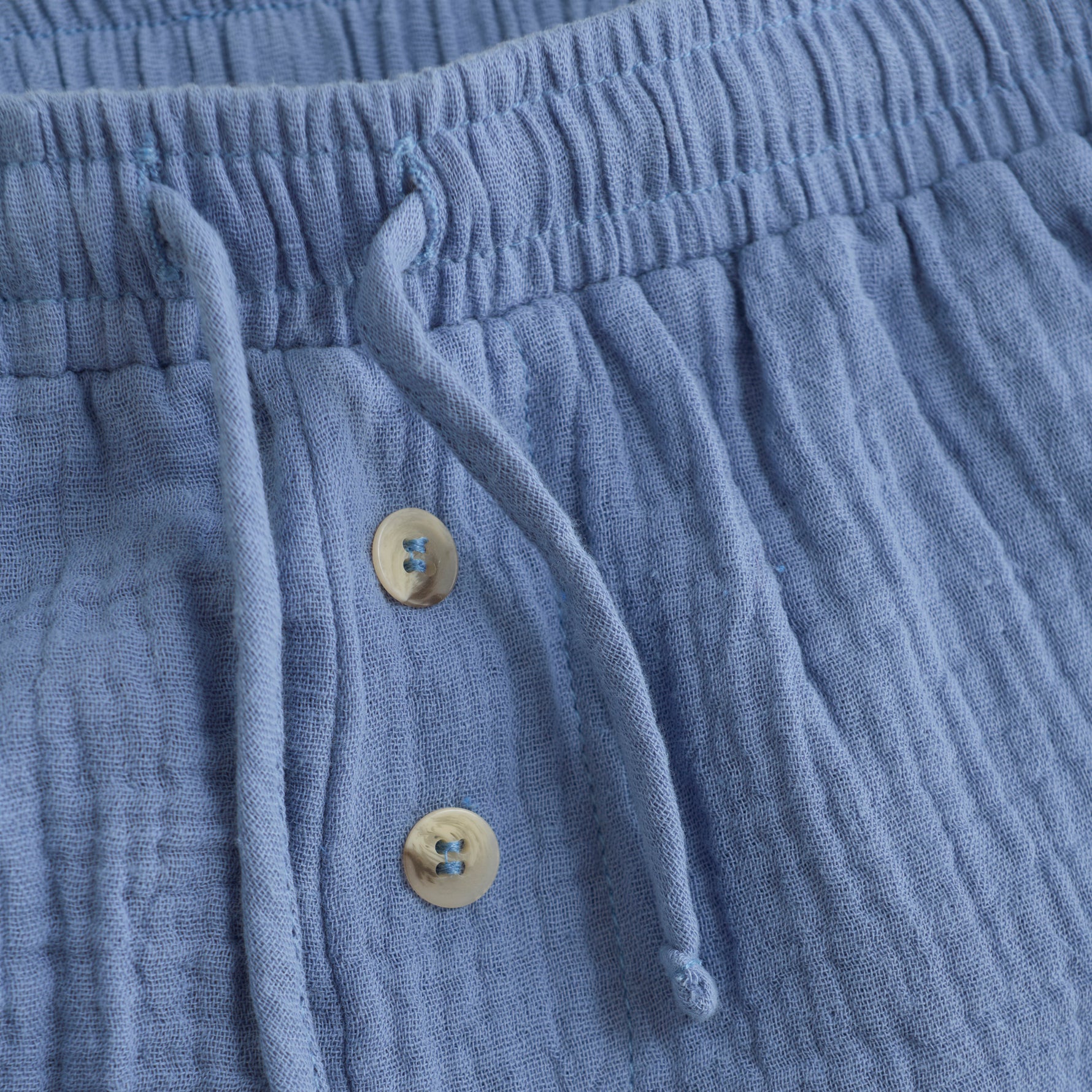 Diese kurze blaue Musselin-Short bietet ein leichtes, atmungsaktives Tragegefühl – perfekt für warme Tage. Ihr weicher Stoff sorgt für angenehmen Komfort, während der lockere Schnitt Bewegungsfreiheit garantiert.&nbsp;