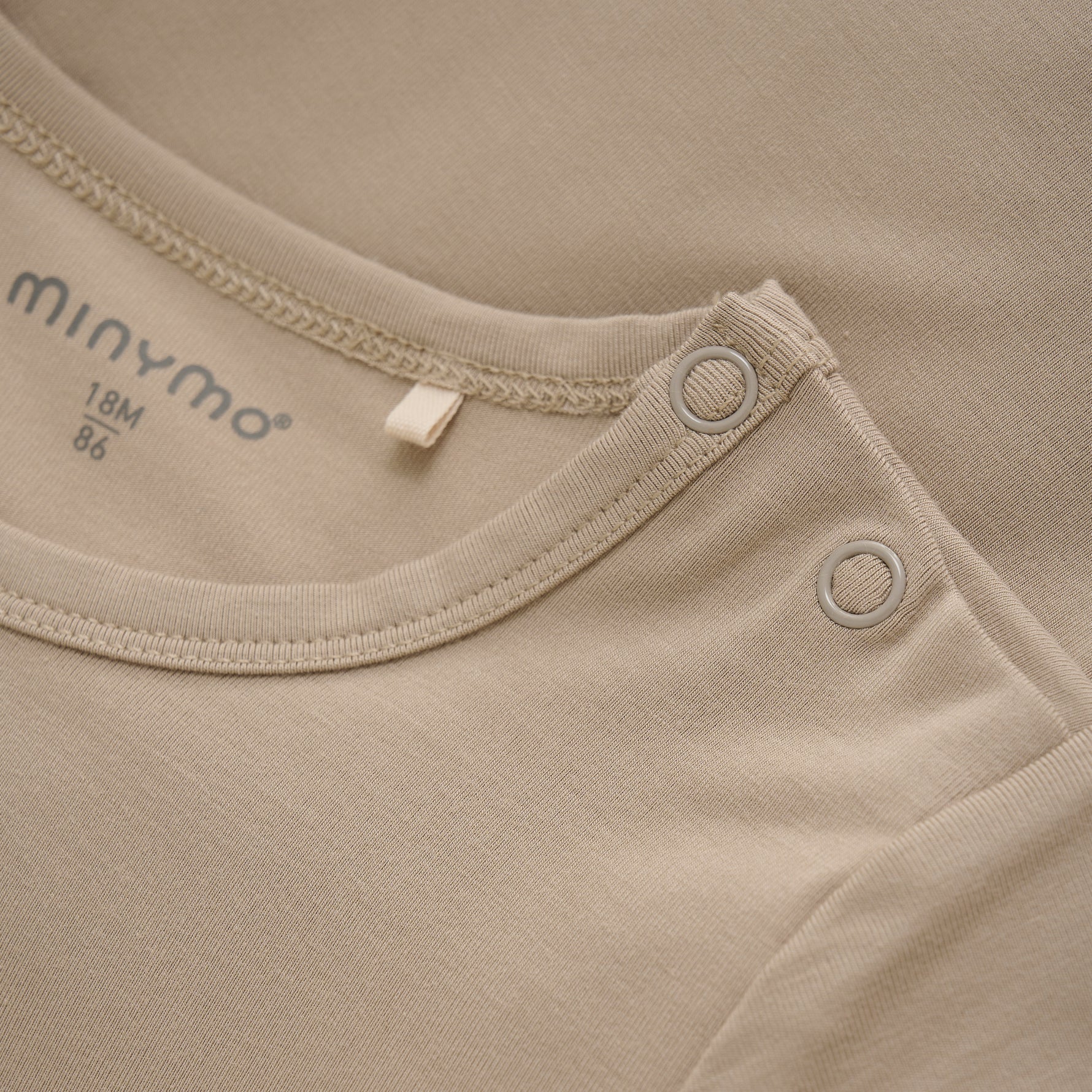 Der bequeme Body in zartem Beige von MINYMO bringt mit seinem schlichten Look spielerische Leichtigkeit in jeden Tag.