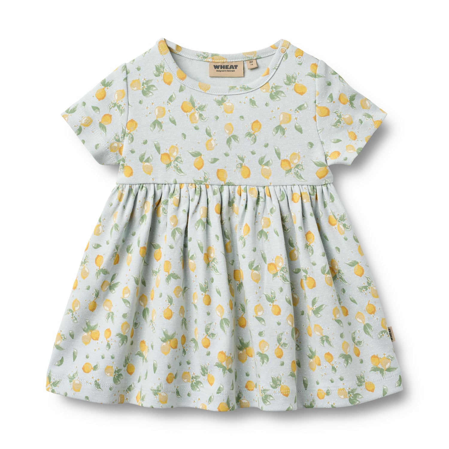 Weiches Jersey-Kleid von WHEAT mit charmanten Zitronen-Allover-Print. Das kurzärmelige Nova Kleid besticht durch seinen verspielten Zitronenmuster und bietet maximalen Tragekomfort dank 100% Bio-Baumwolle. Perfekt für warme Tage – leicht, atmungsaktiv und hautfreundlich. Ein zeitloses Lieblingsstück für jeden Sommer.