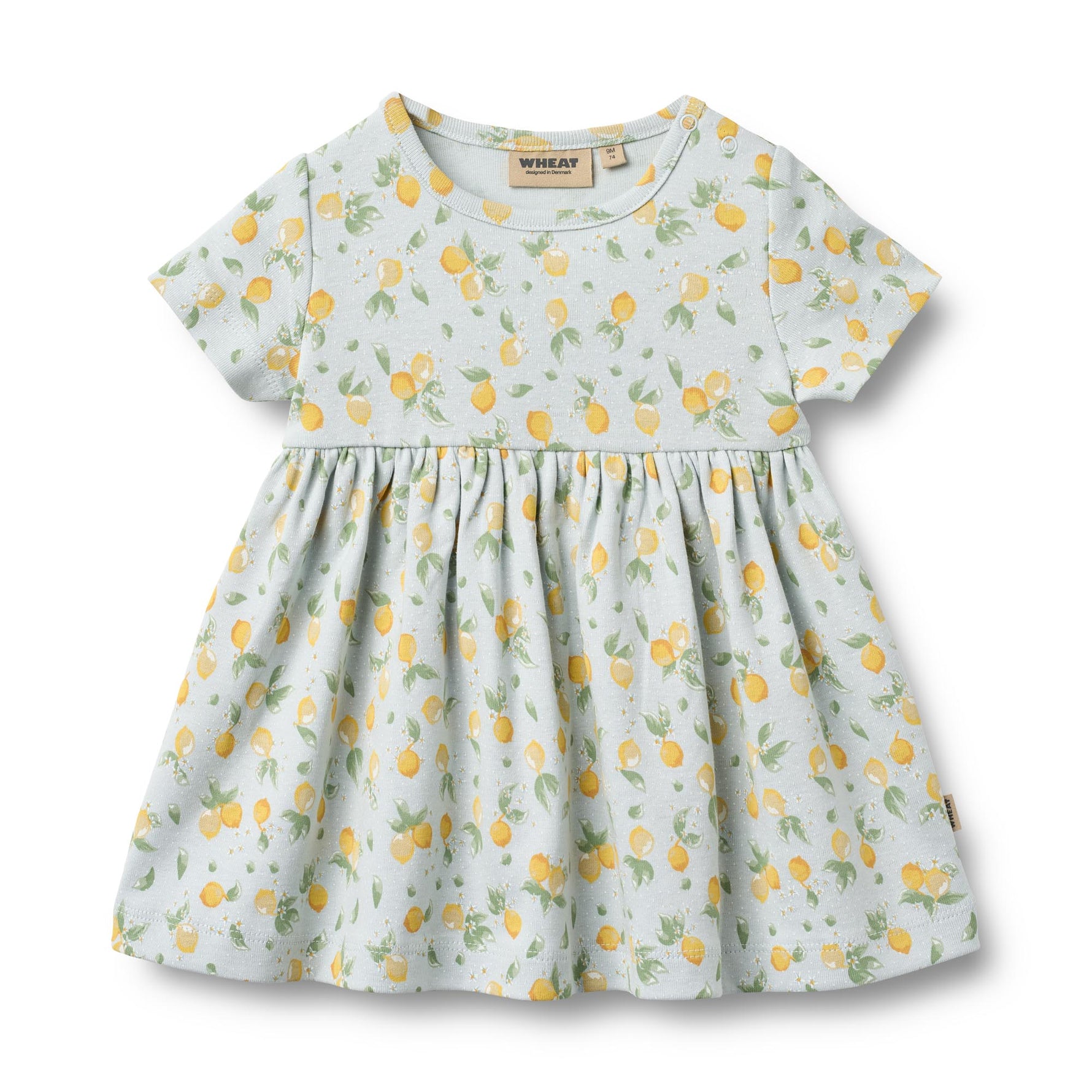 Weiches Jersey-Kleid von WHEAT mit charmanten Zitronen-Allover-Print. Das kurzärmelige Nova Kleid besticht durch seinen verspielten Zitronenmuster und bietet maximalen Tragekomfort dank 100% Bio-Baumwolle. Perfekt für warme Tage – leicht, atmungsaktiv und hautfreundlich. Ein zeitloses Lieblingsstück für jeden Sommer.