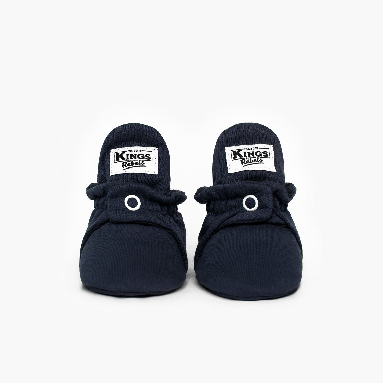Die Kings &amp; Rebels Baby Booties wurden mit einem einfachen und praktischen Druckknopf- Verschluss entworfen, was das Anziehen von strampelnden Babys in wenigen Sekunden ermöglicht.

Der komplett um die Ferse verlaufende und über dem Knöchel sitzende, integrierte Gummizug verhindert auch bei sehr aktiven Babys das Herunterrutschen des Booties.

Alle Modelle der ´Cotton Classic´ und ´Cotton Gripper´ Linie sind aus haut- und umweltfreundlicher Baumwolle gefertigt, was für hohen Tragekomfort auch bei frühli