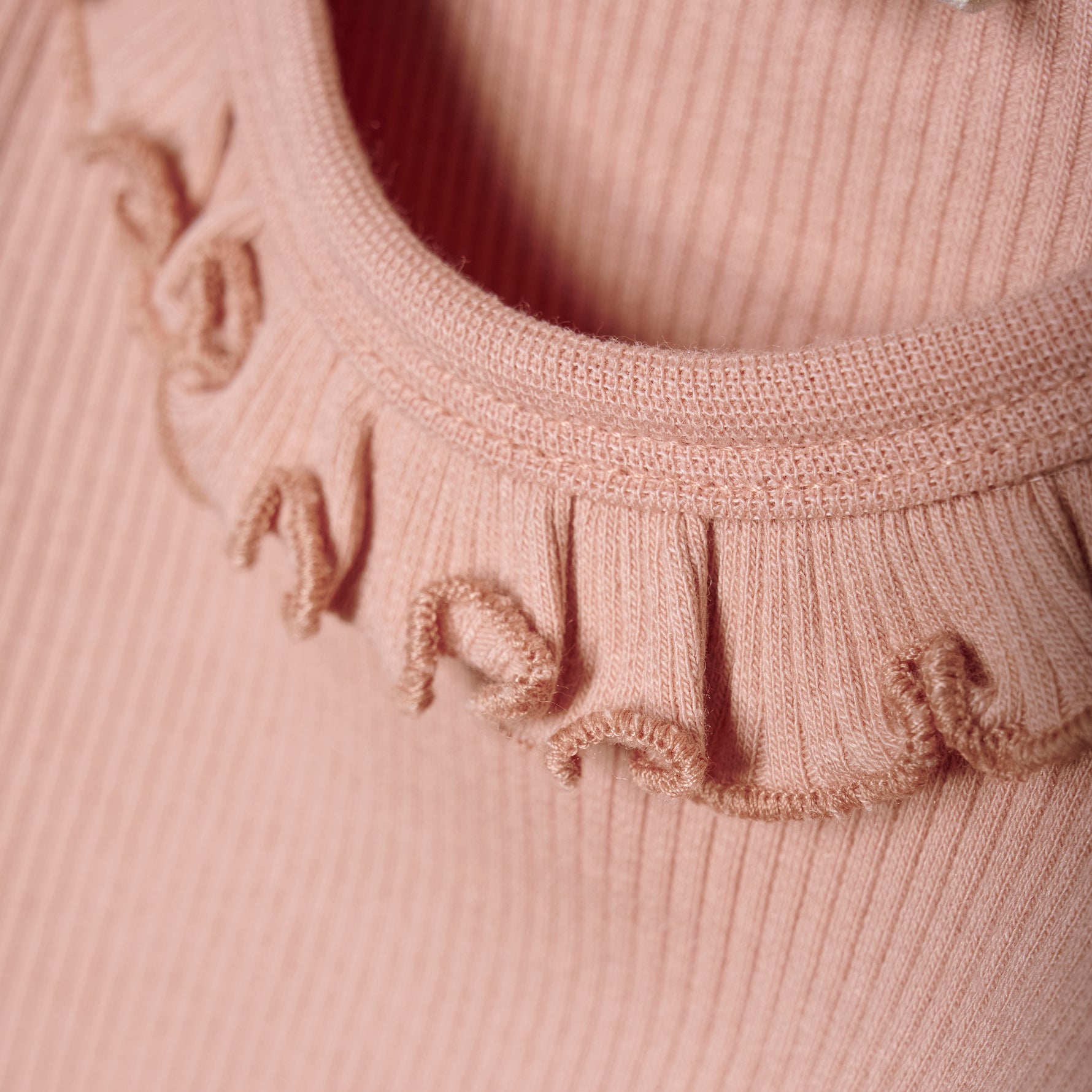 Dieses rosa Body mit verspieltem Rüschenkragen von MINYMO verleiht jedem Outfit einen charmanten Akzent.